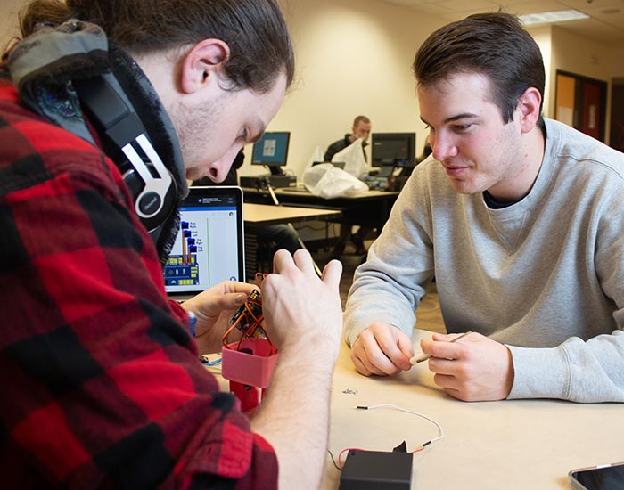 students working on an electronic device