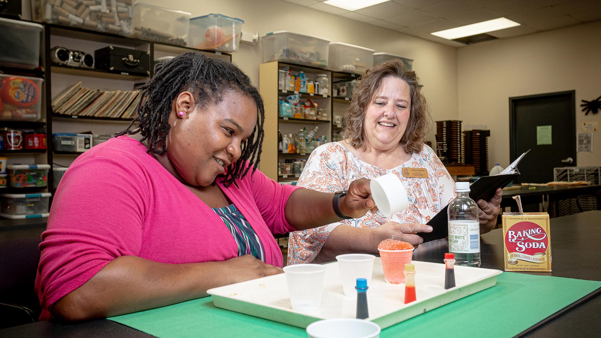 Female student and professor conducting baking soda educational experiment