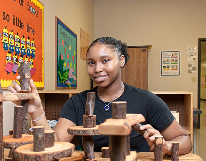 Female student working with logs - early childhood care / education