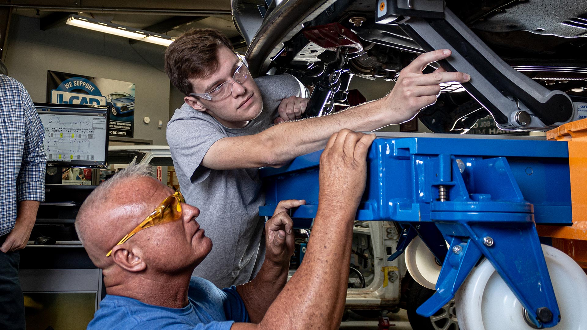 Student and professor working on car from collision repair