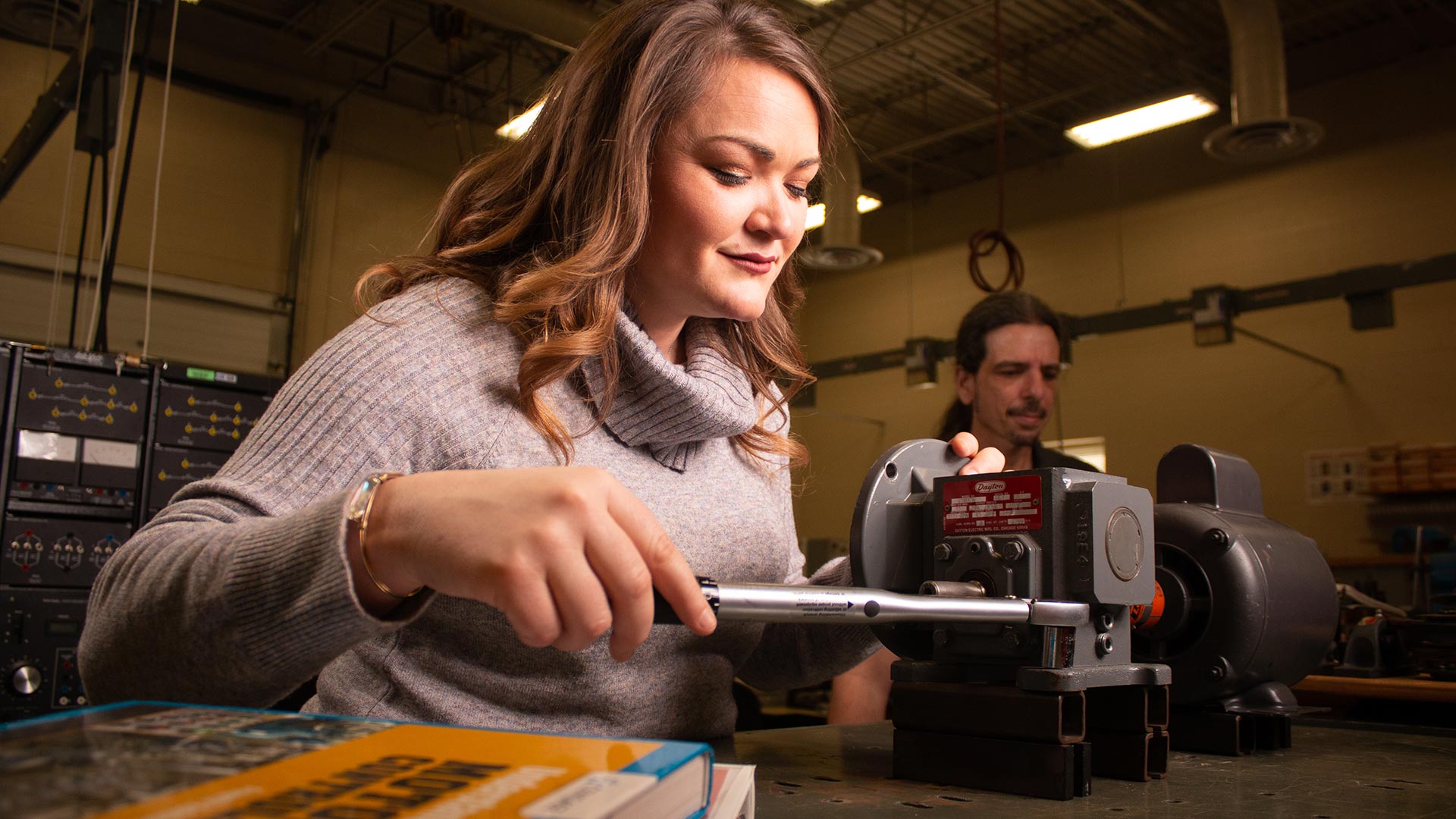 female student working hands on w/ industrial systems device