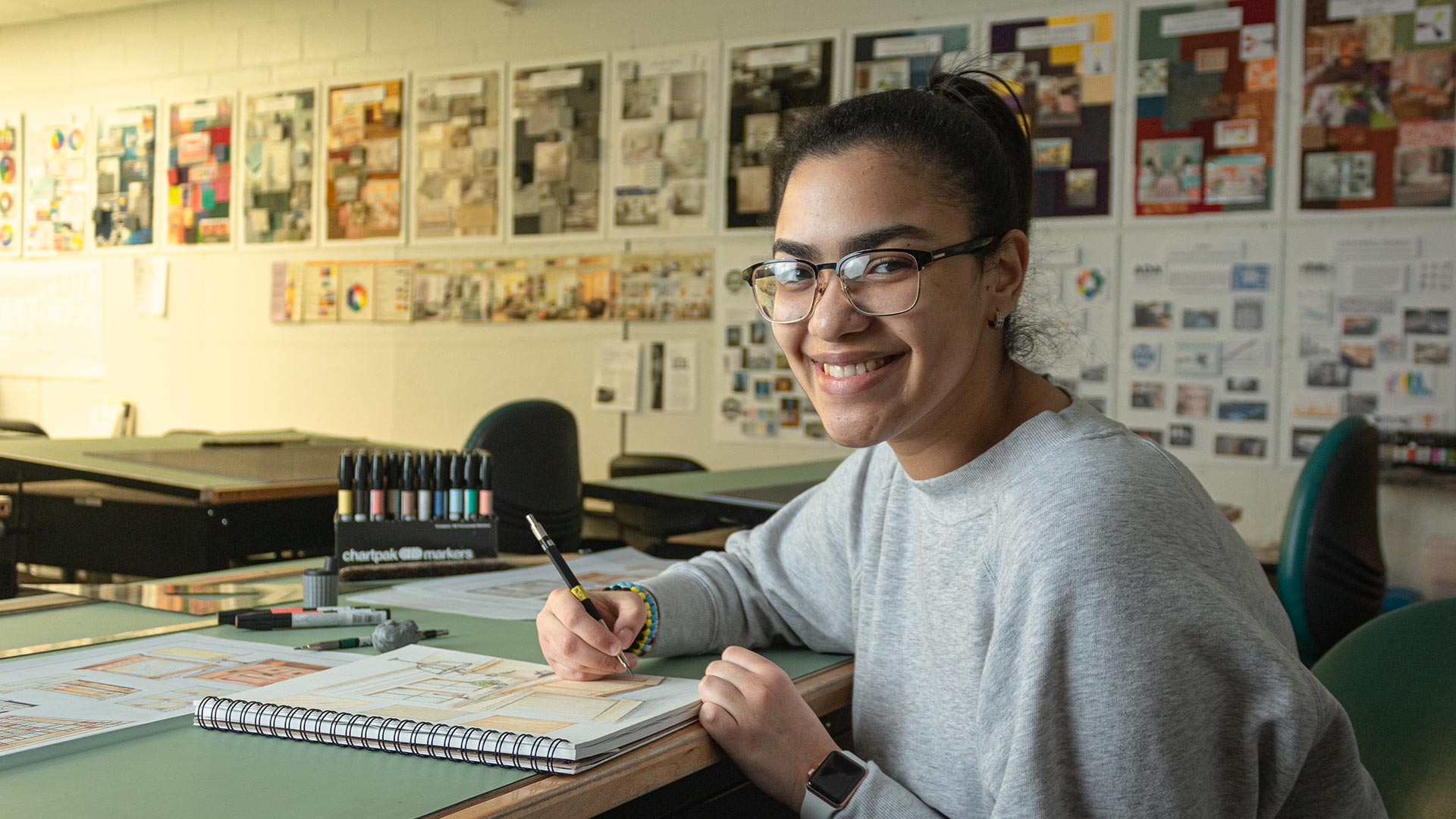 Female student drafting in interior design notebook