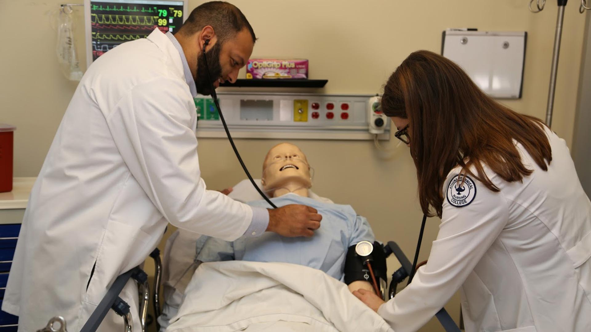 Nursing students checking blood pressure and heartbeat on a dummy