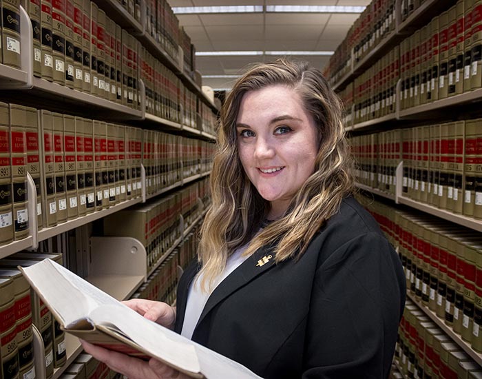 Student in library holding open book