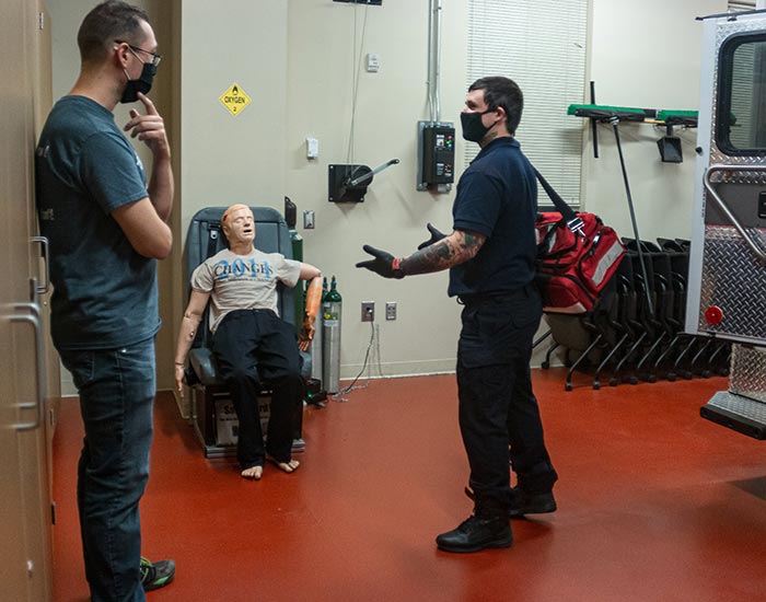 Students talking while dummy is in wheelchair