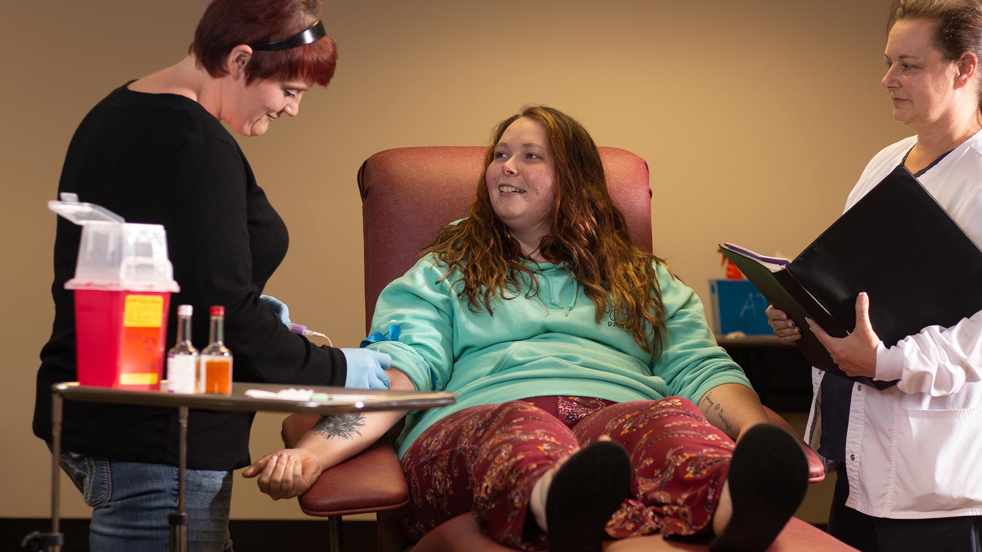 Student sitting in chair getting blood drawn by another student