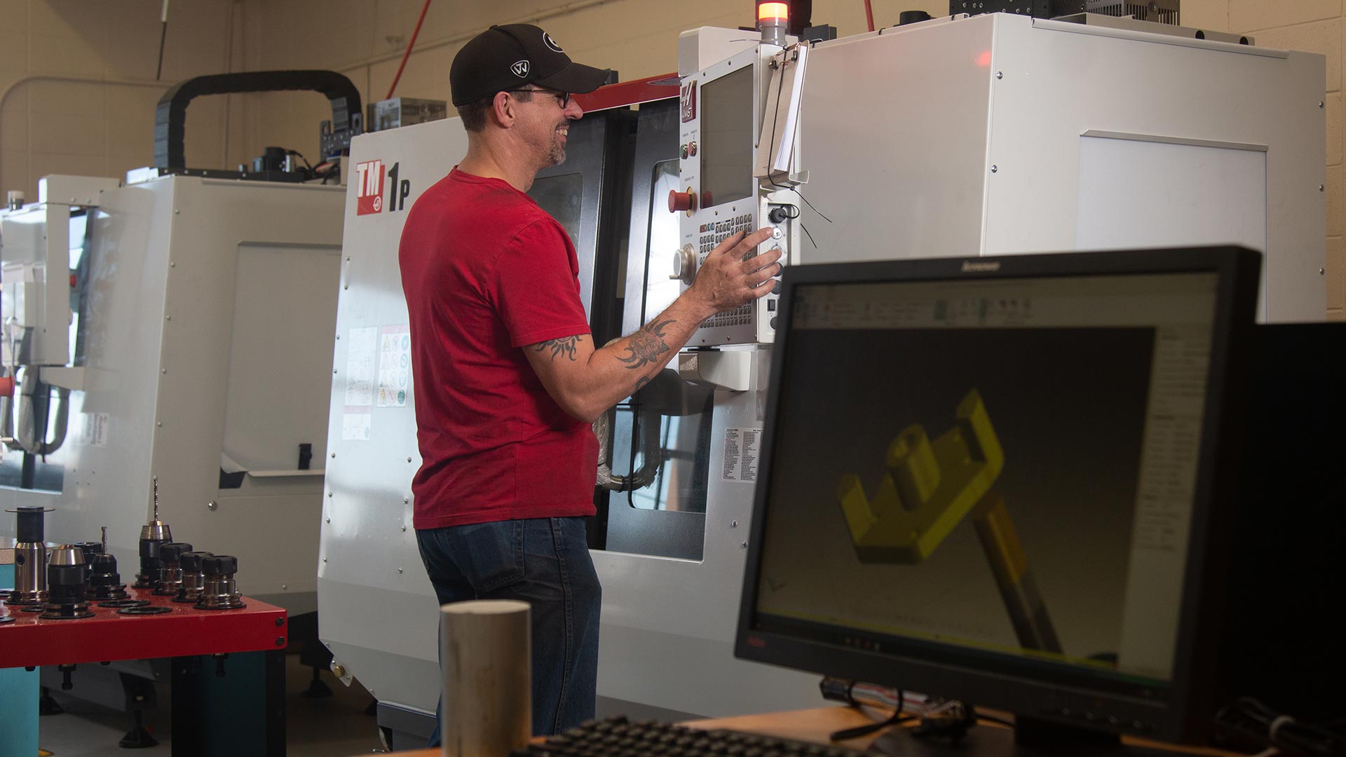 Student smiling while looking at screen of precision machine