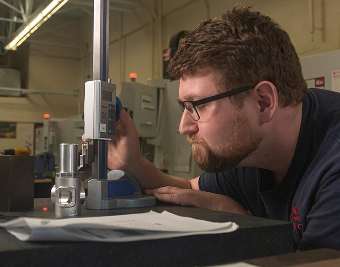 male student working w/ precise machine