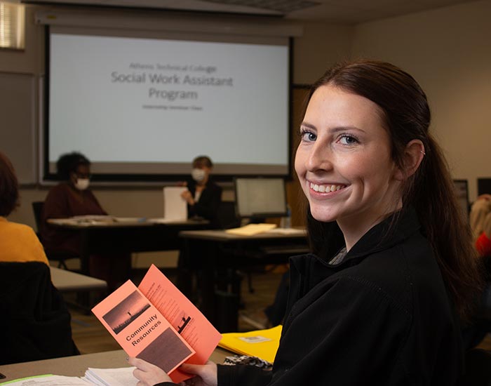 female student w/ community resources brochure - Social work assistant