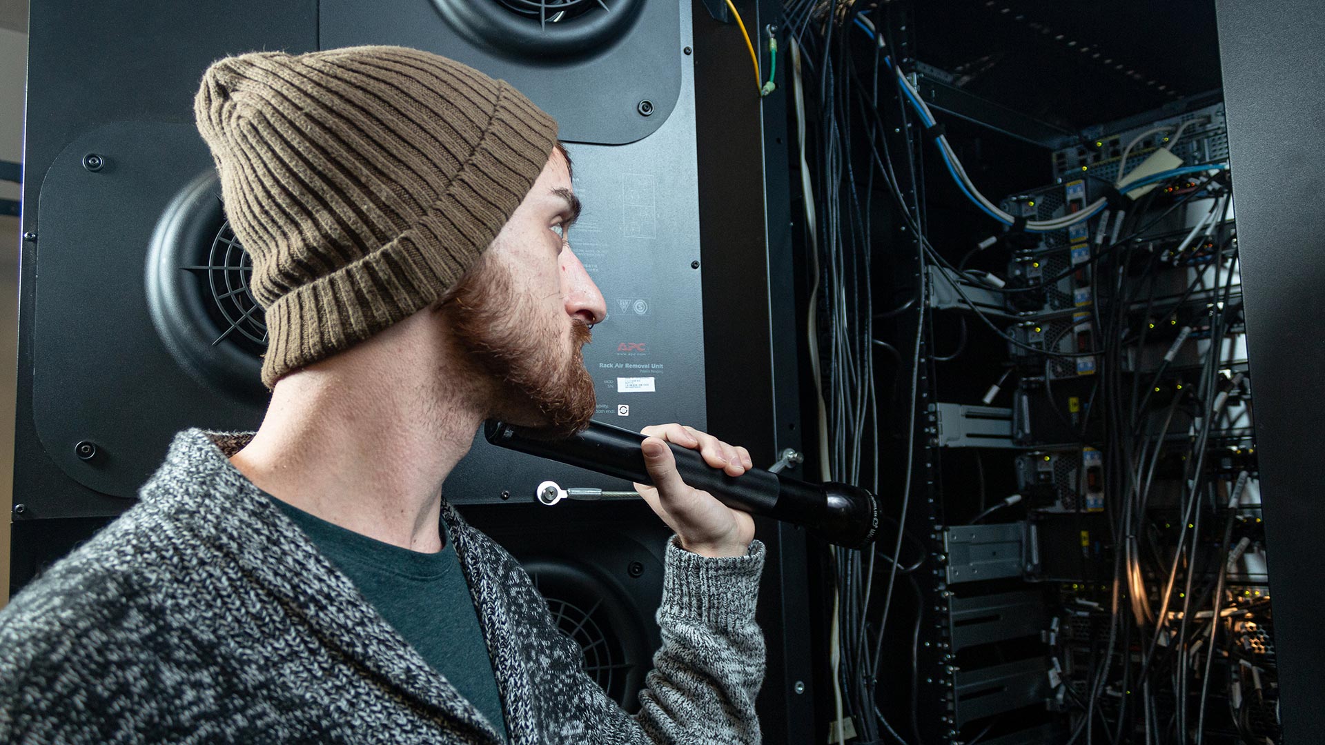 Male student holding flashlight at network box - network specialist