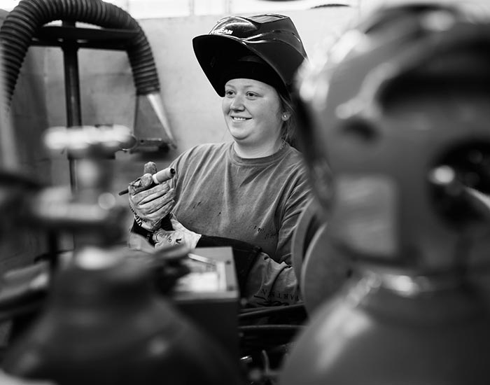 female welding student smiling with mask off